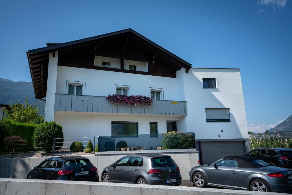 a white house with cars parked in front of it at Haus Beim Seppl in Naturno