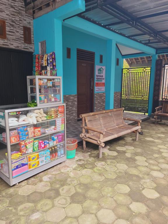 a store with a bench and a blue building at Homestay Barokah in Magelang