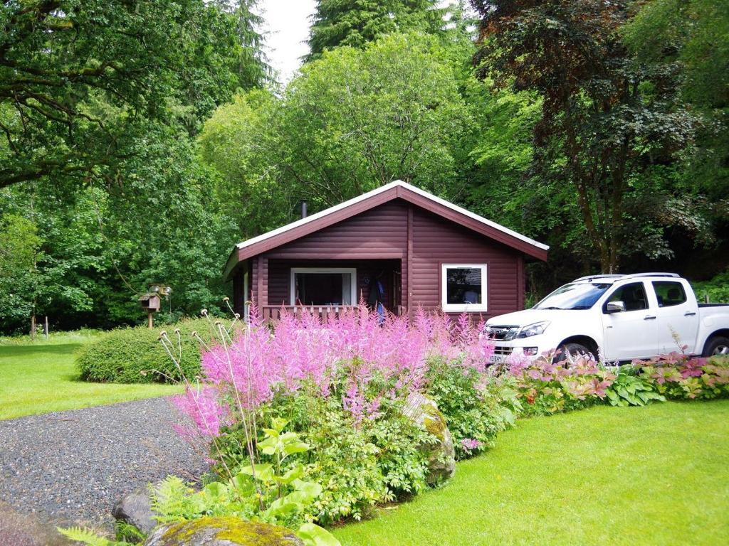 a small house with a white truck parked in front of it at Ard Darach Lodge in Brinscall