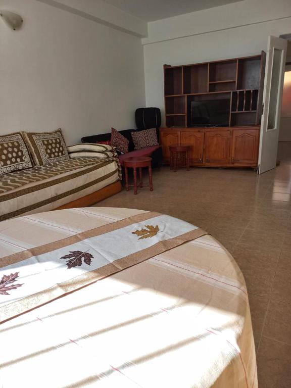 a living room with two beds and a flat screen tv at STAR APPARTEMENT GAUTHIER in Casablanca