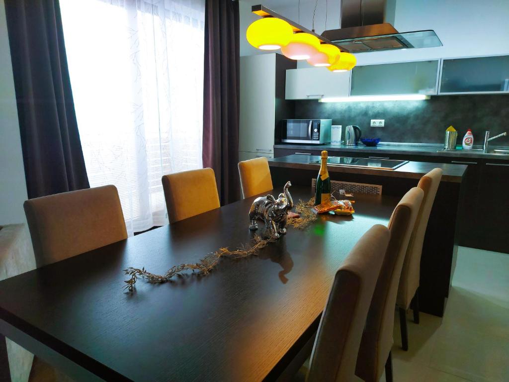 a dining room table with a bottle of wine on it at A&M Apartment Donovaly in Donovaly