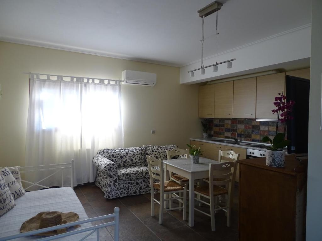 Il dispose d'une cuisine et d'un salon avec une table et un canapé. dans l'établissement Naiad Studio, à Poros
