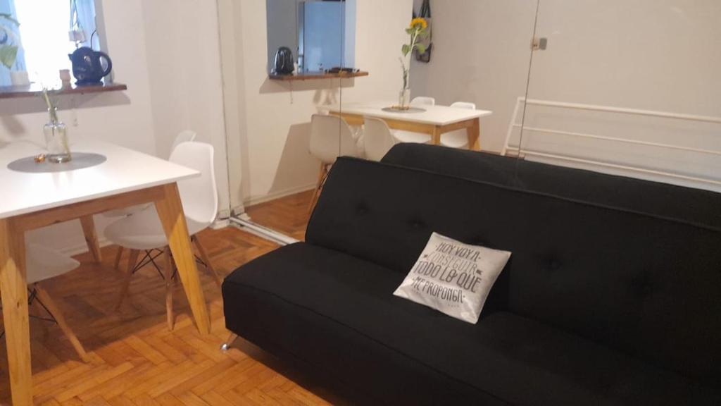sala de estar con sofá negro y almohada en Departamento tipo duplex 2 ambientes Belgrano en Buenos Aires