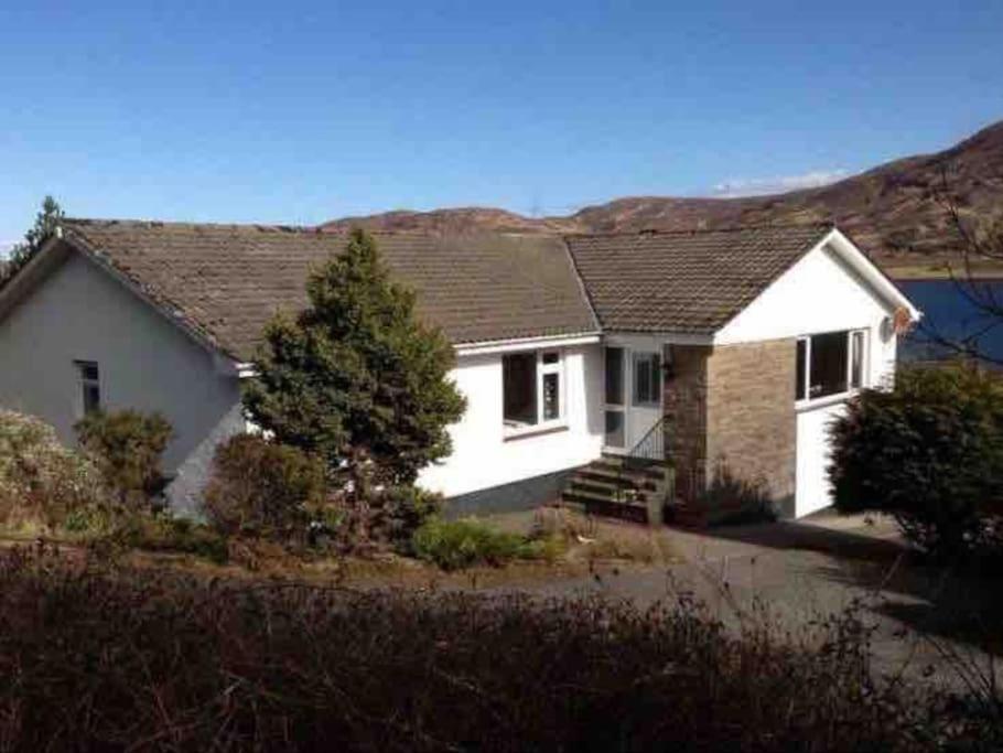 een wit huis met een dak bij Dunmara: Self Catering Cottage on the Isle of Skye in Broadford