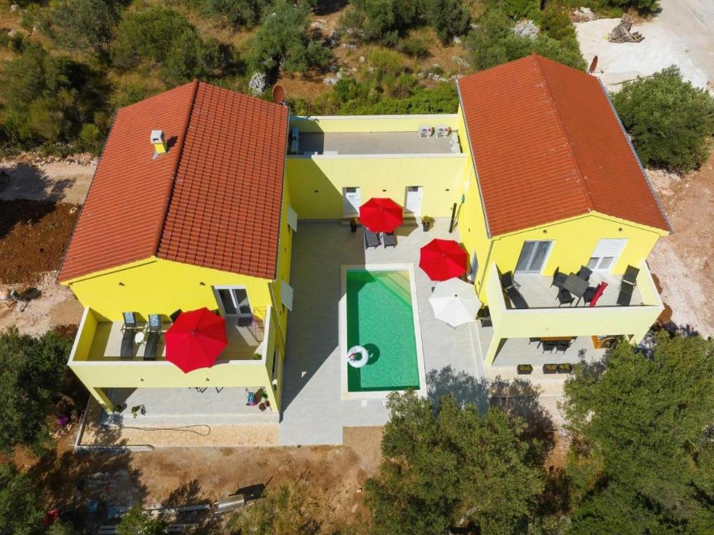 una vista aérea de una casa amarilla con techos rojos en Luxury Villa Gaby with Heated Pool en Božava