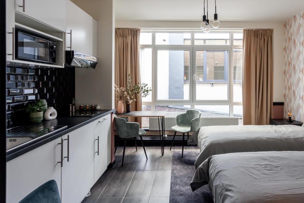 sypialnia z 2 łóżkami i kuchnia ze stołem w obiekcie Hey - Aparthotel Brussels w Brukseli