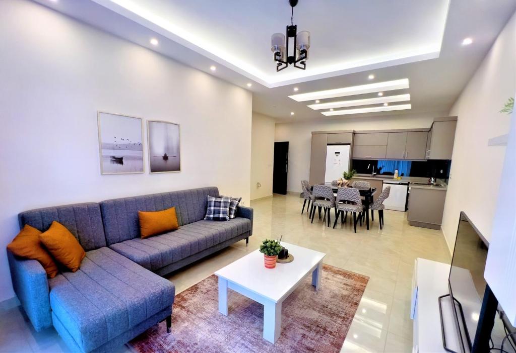 a living room with a couch and a table at Flat with Shared Pool and Backyard in Alanya in Avsallar