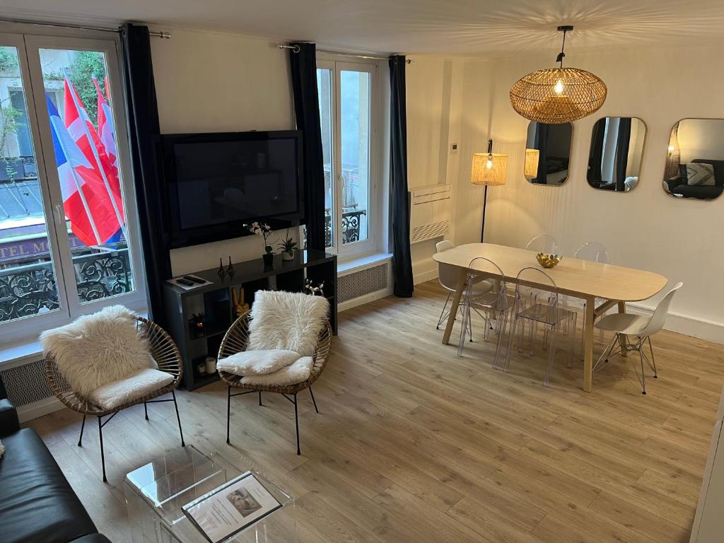 - un salon avec une table, des chaises et une télévision dans l'établissement NOTRE DAME - STYLISH APARTMENT, à Paris