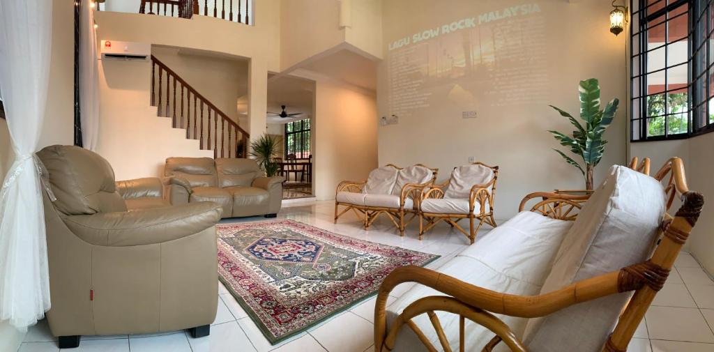 a living room with couches and chairs and a rug at D Riad Ipoh Homestay l Home Cinema l 300MBPS in Ipoh