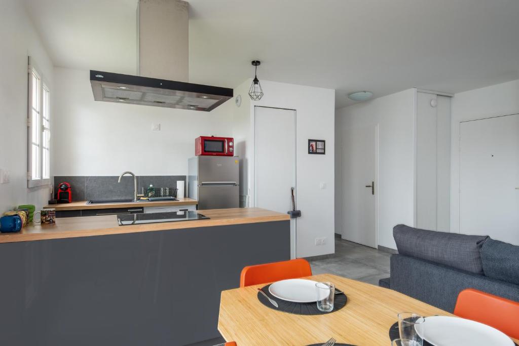 a kitchen and living room with a table and a couch at T2 Marvel Apartment Near DisneylandParis in Serris
