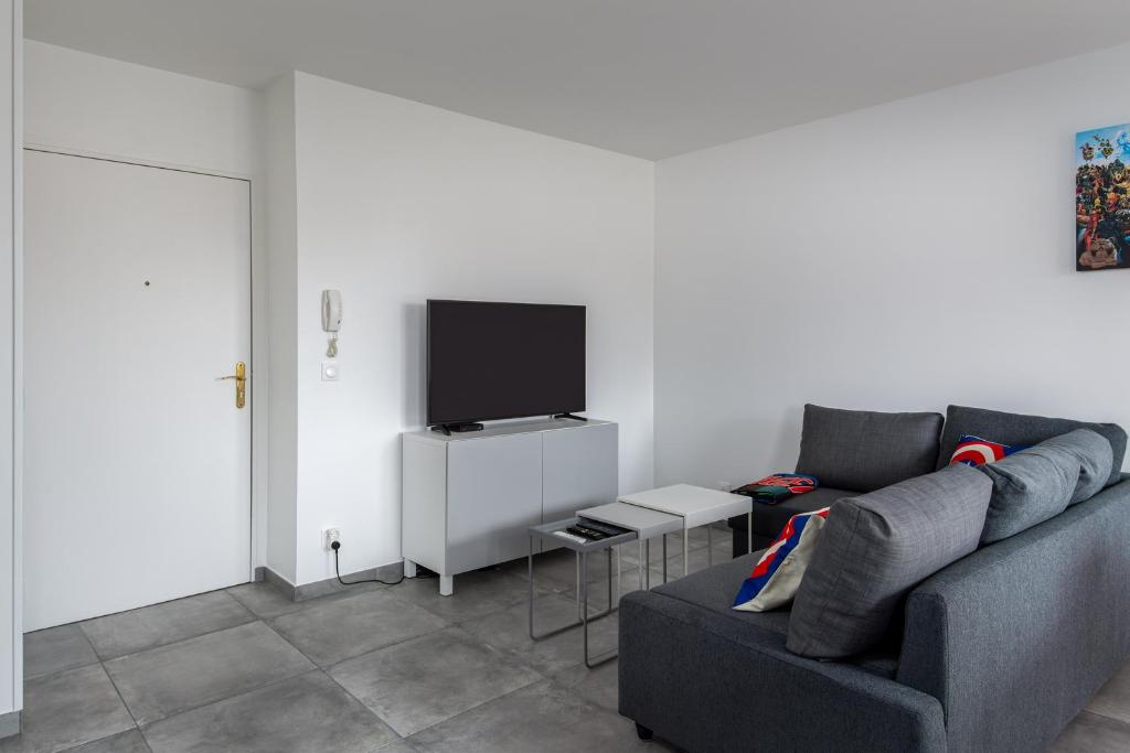 a living room with a couch and a flat screen tv at T2 Marvel Apartment Near DisneylandParis in Serris