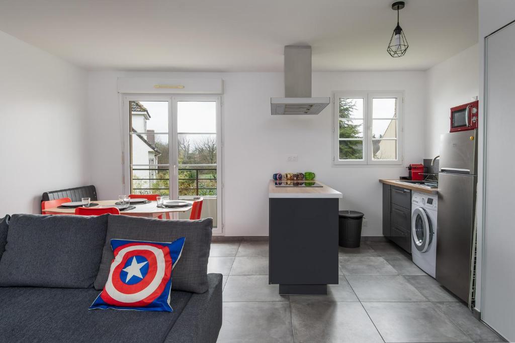 a living room with a gray couch and a kitchen at T2 Marvel Apartment Near DisneylandParis in Serris