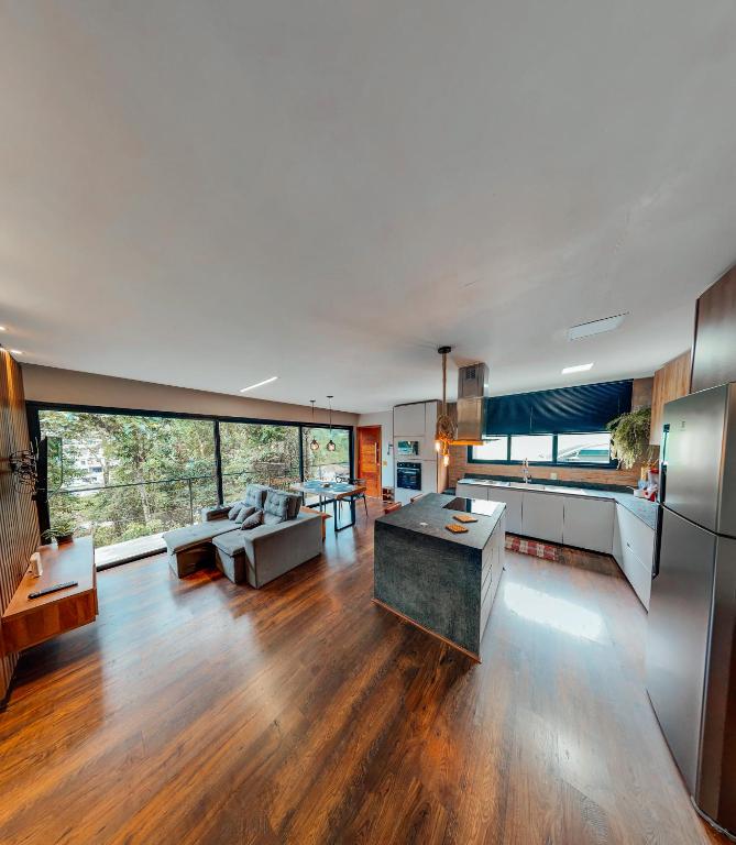 a large kitchen and living room with wooden floors at Casa Recanto da Neblina in Petrópolis