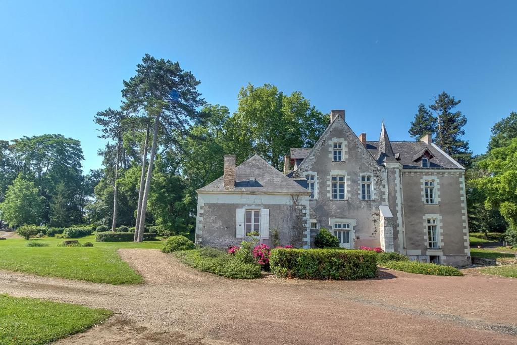 une ancienne maison en pierre avec une allée. dans l'établissement Magnifique château au bord de la Mayenne 18 couchages, 