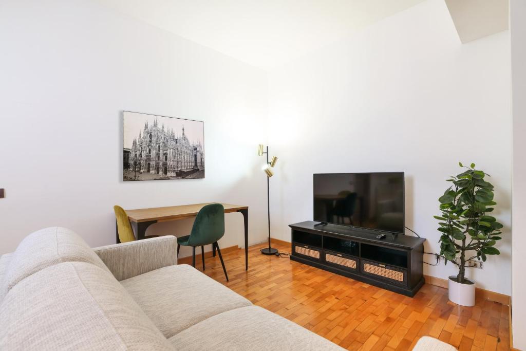 salon z kanapą, telewizorem i stołem w obiekcie Duomo Luxury Apartment VIII w Mediolanie