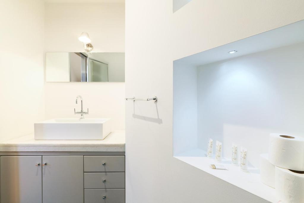 biała łazienka z umywalką i lustrem w obiekcie Duomo Luxury Apartment VIII w Mediolanie