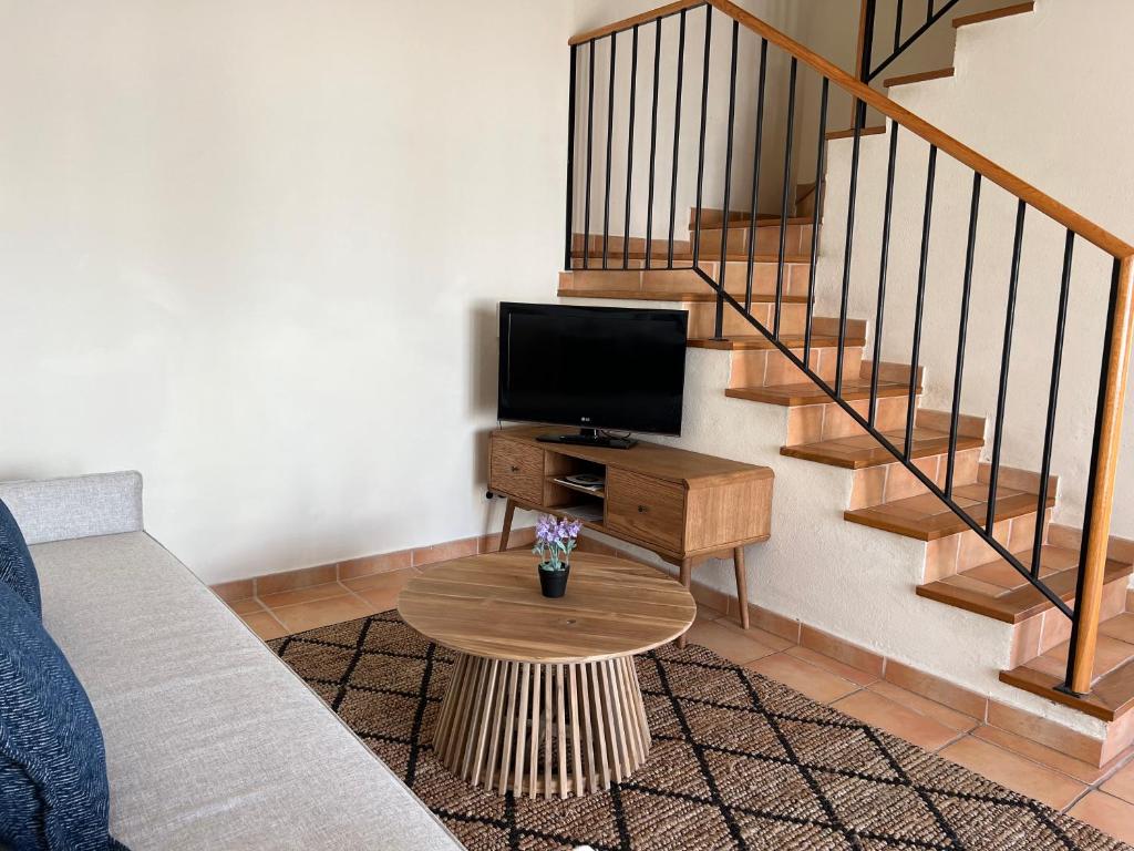 a living room with a couch and a tv and stairs at Pestana Palm Gardens in Carvoeiro
