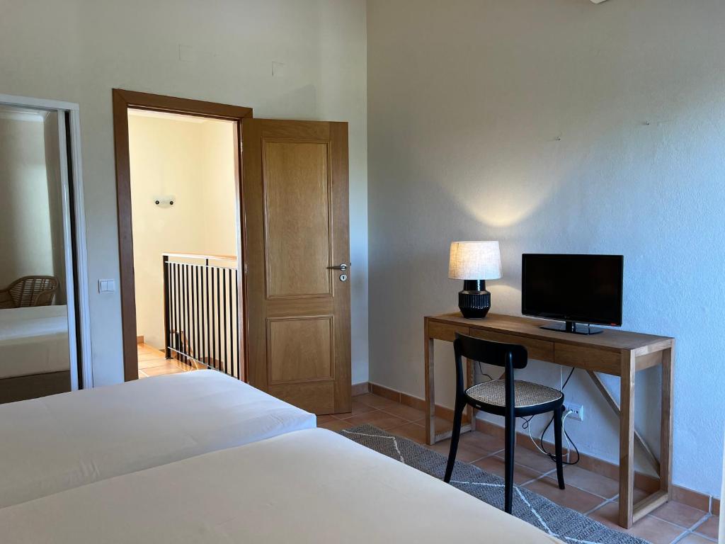 a bedroom with a bed and a desk with a computer at Pestana Palm Gardens in Carvoeiro