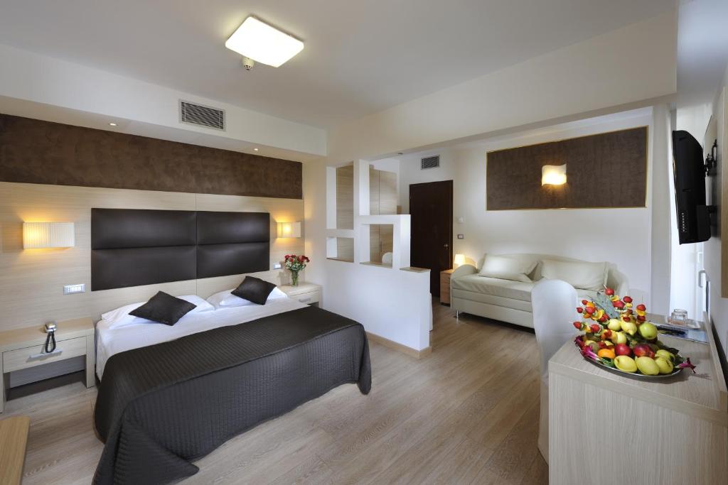 een slaapkamer met een bed en een woonkamer bij Hotel Eros in Lignano Sabbiadoro