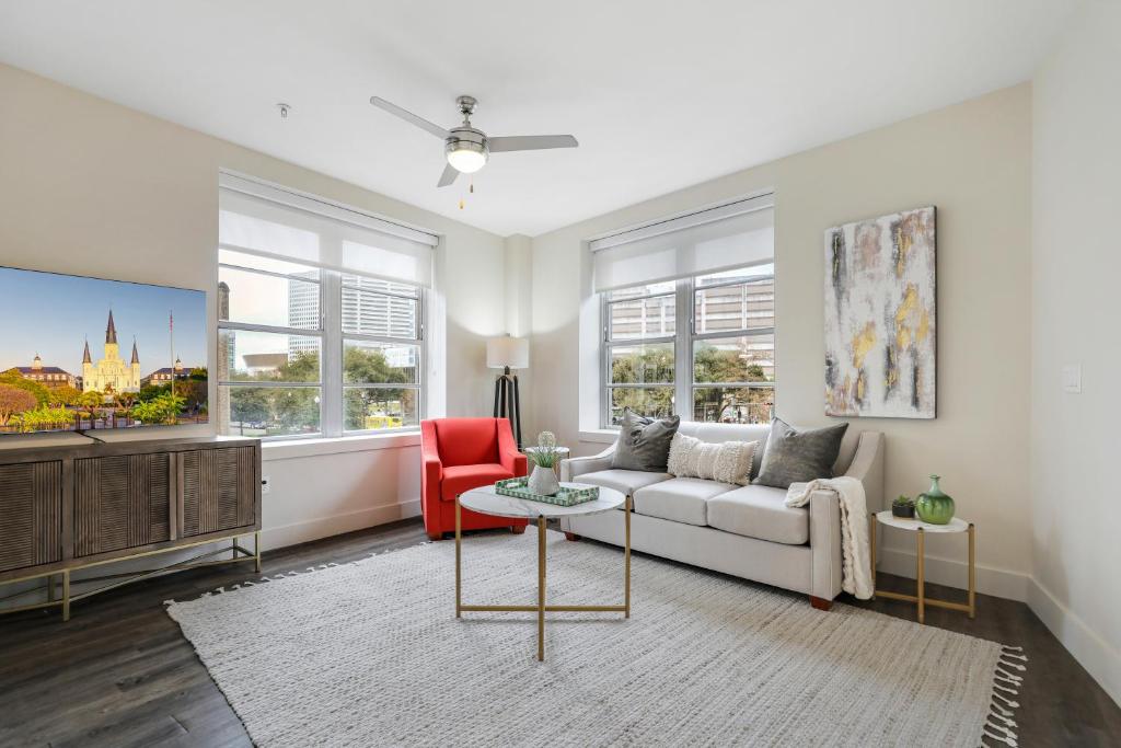 uma sala de estar com um sofá branco e uma cadeira vermelha em 2 Bedroom Elegant condos in Downtown New Orleans em Nova Orleans