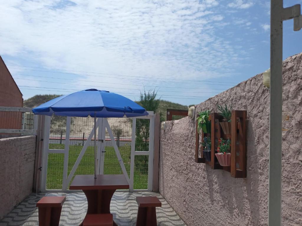 une terrasse avec une table et un parasol dans l'établissement Lindo Duplex à 50 metros da praia, à Imbé