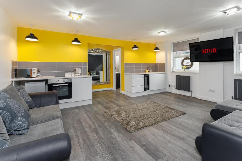 a living room with a couch and a tv at Snuggle Cove Apartments By Bella Vita Stays in Liverpool