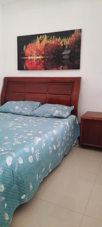 um quarto com uma cama com um quadro na parede em My Flat em Praia