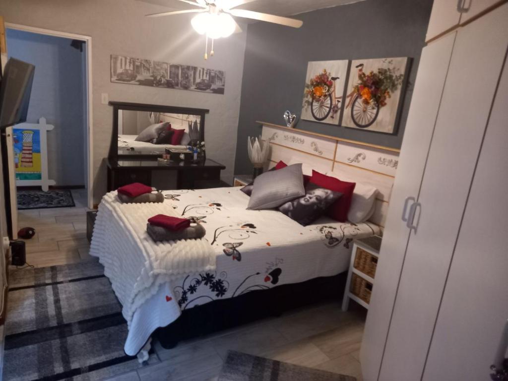 1 dormitorio con 1 cama grande y espejo en Chardonnay Holiday Apartment, en Jeffreys Bay