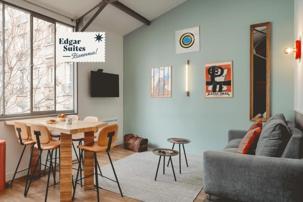 un salon avec une table et un canapé dans l'établissement Edgar Suites Martyrs - Loft, à Paris