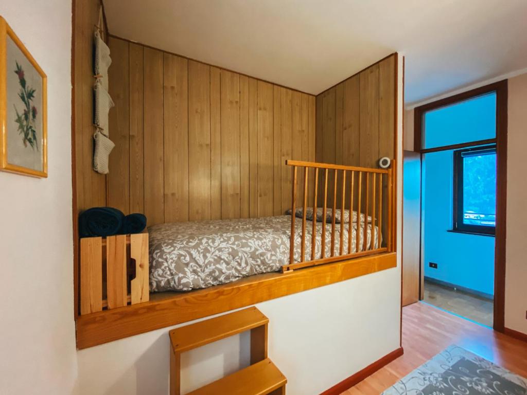 a bedroom with a bed in a wooden wall at Appartamento panoramico in Sùtrio