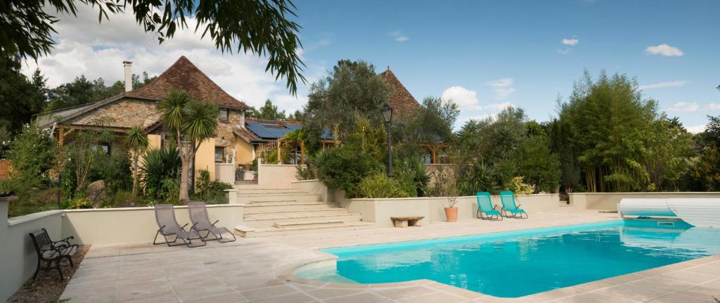 - une piscine avec des chaises à côté d'une maison dans l'établissement Domaine Hourcabis - 2 gîtes 4 et 6 personnes, 