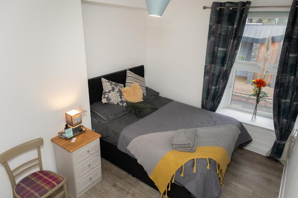 a small bedroom with a bed and a window at Au Centre-Ville in Lisnaskea