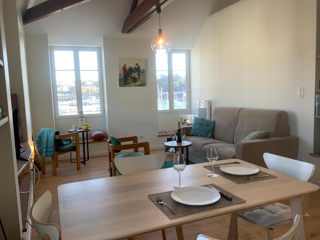 un soggiorno con tavolo e divano di Appartement du Port - Audierne ad Audierne