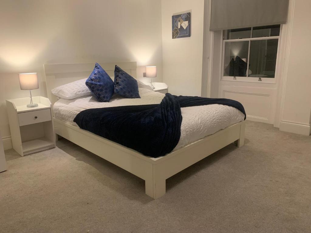 Un dormitorio con una cama con almohadas azules y una ventana en HU1 Triplex City Centre Gem sleeps 6 H7, en Hull