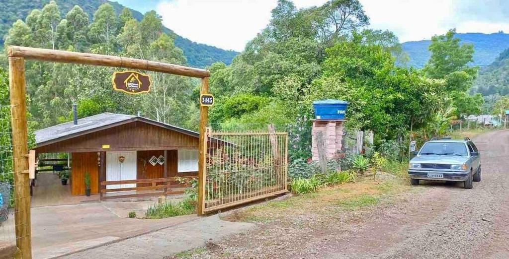 a car parked next to a building on a dirt road at Chalé Recanto dos Pássaros in Gramado