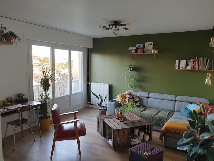 uma sala de estar com um sofá e uma mesa em T2 refait à neuf entre Paris et Disneyland Paris em Rosny-sous-Bois