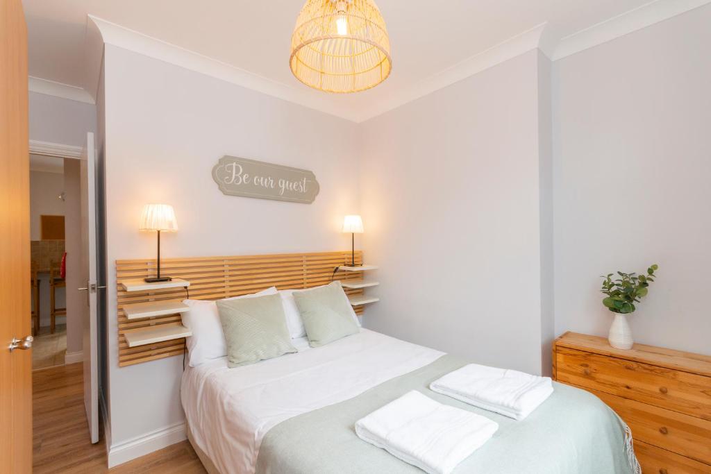sypialnia z dużym białym łóżkiem z białymi poduszkami w obiekcie The Nook by Afan Valley Escapes w mieście Port Talbot