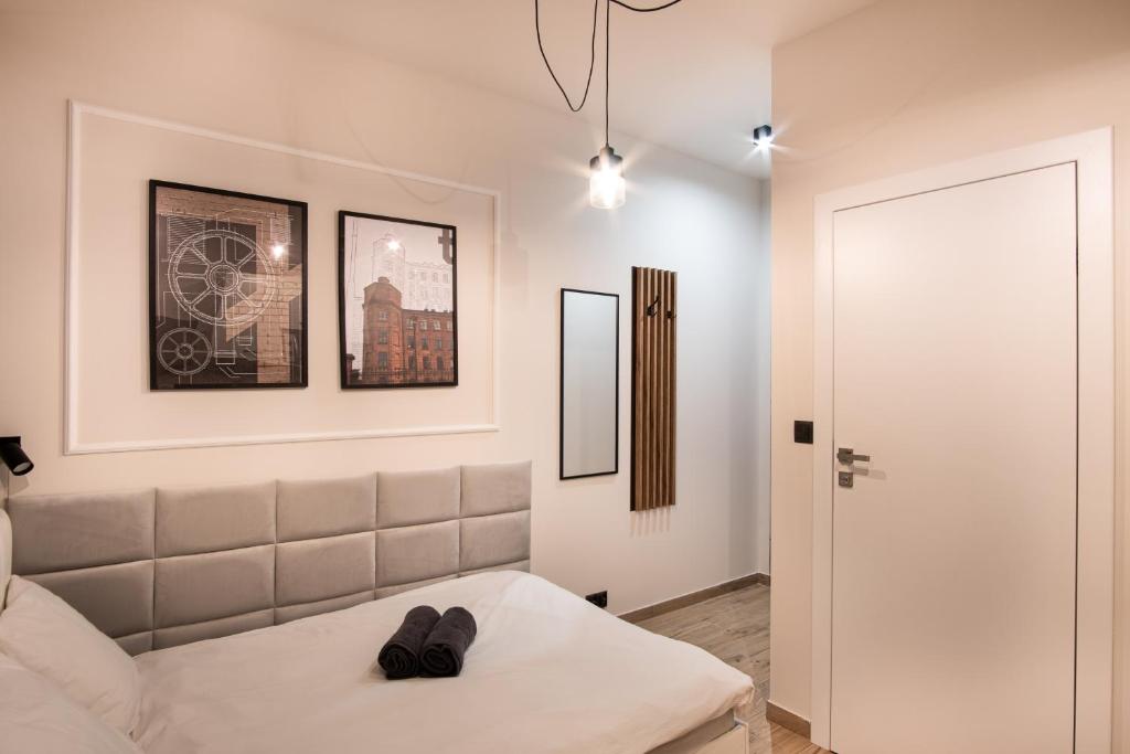 a white room with a bed and a door at Dream Apartments - Gdańska 72 in Łódź