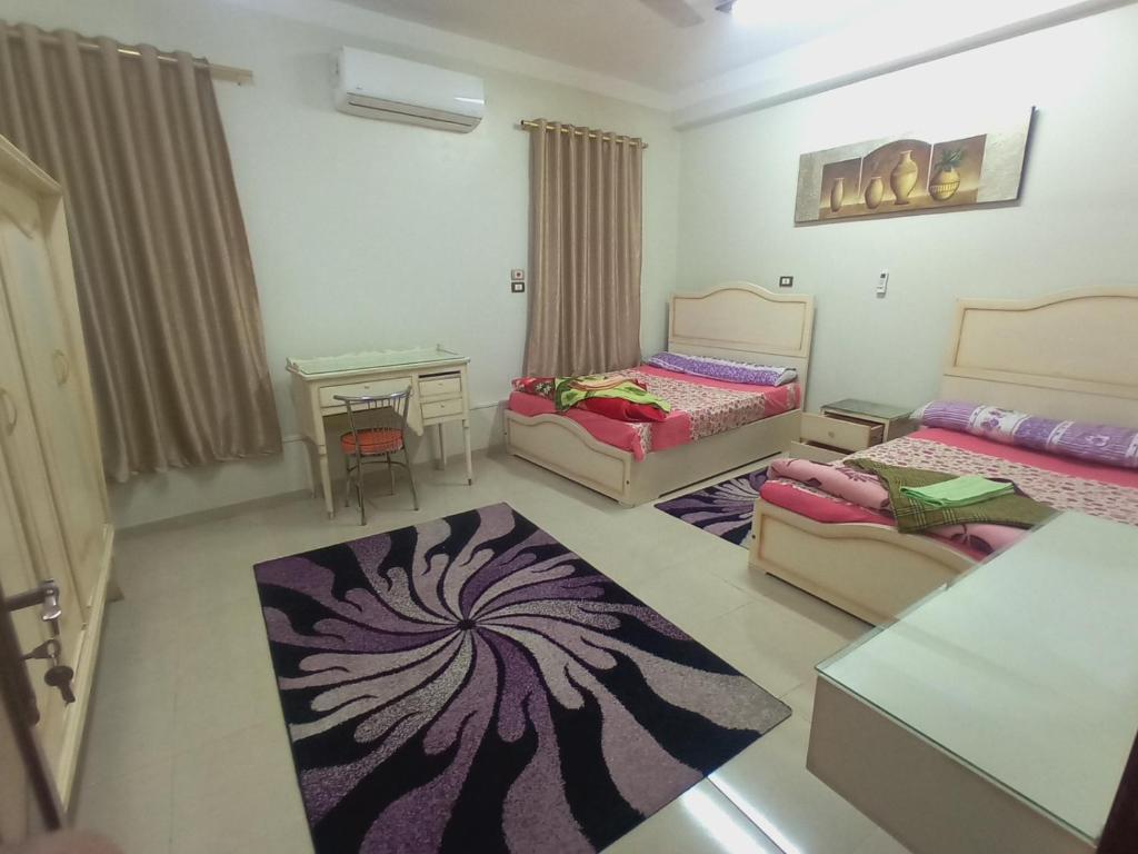 ein Wohnzimmer mit 2 Betten und einem Tisch in der Unterkunft City Center Guest house and Hostel in Assuan