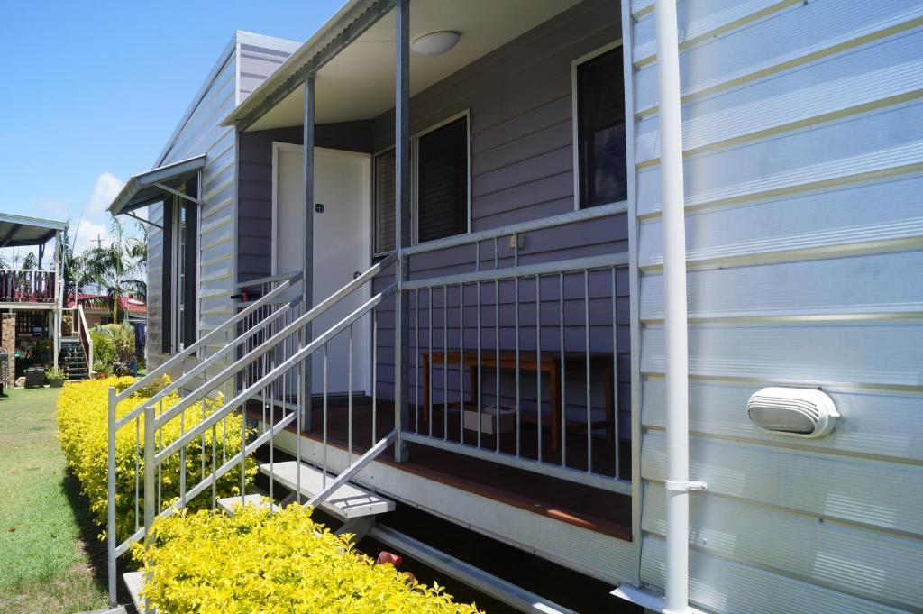 a house with a metal railing on the side of it at Tin Can Bay's Sleepy Lagoon Motel in Tin Can Bay