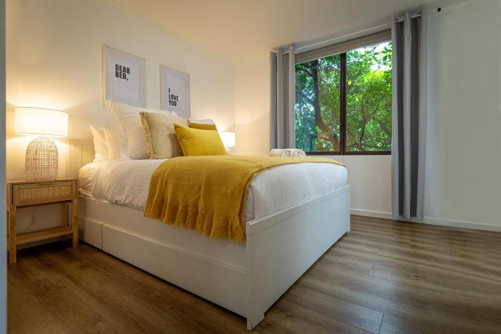 ein Schlafzimmer mit einem Bett mit einer gelben Decke darauf in der Unterkunft Moonee Ponds’ hidden gem – 1BR w/ Free Parking in Melbourne