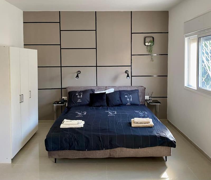 a bedroom with a blue bed with two towels on it at Haifa boutique apartment by LIME in Haifa