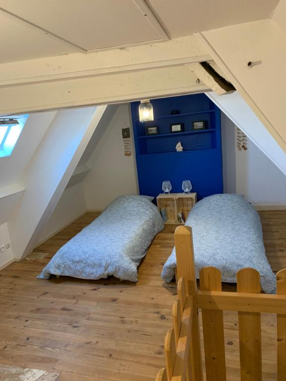 two beds in a room with blue walls and wooden floors at Authentique maison de pêcheur à Port-en-Bessin in Port-en-Bessin-Huppain