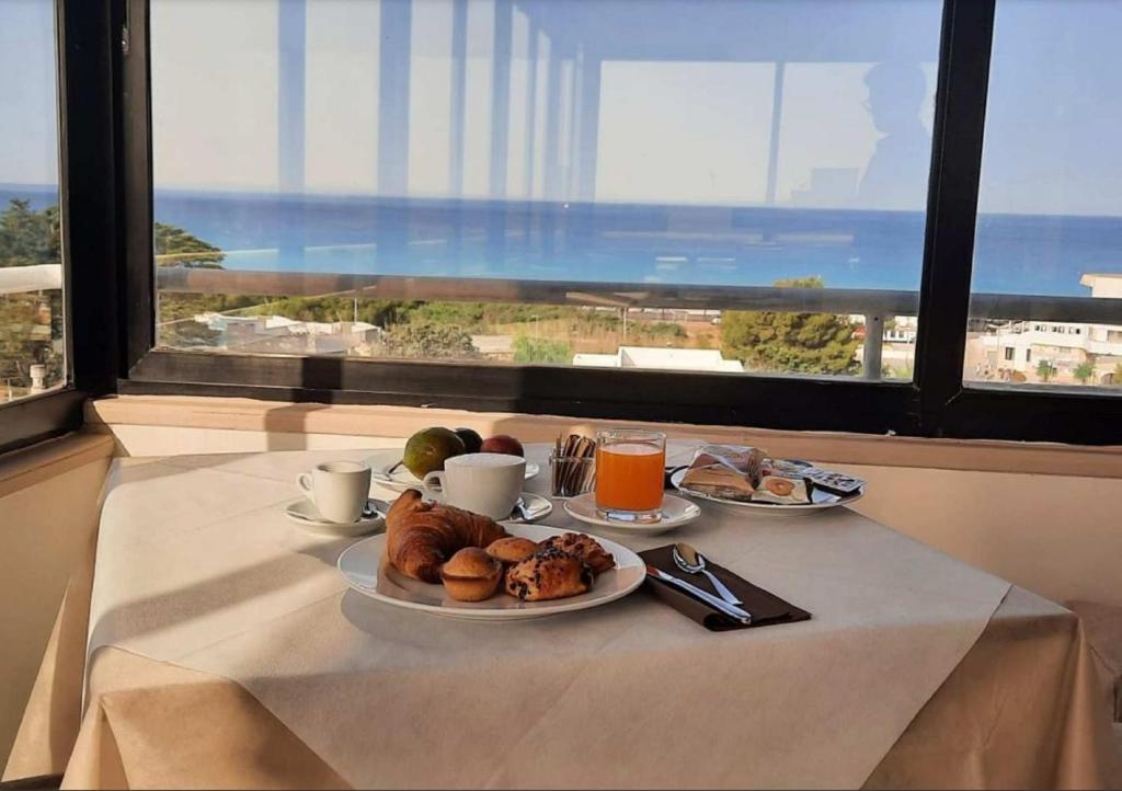 una mesa con una bandeja de comida para el desayuno y una ventana en Hotel Baia Verde Gallipoli, en Gallipoli