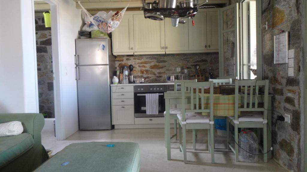 a kitchen with a refrigerator and a table and chairs at Serifos Dream Houses near the sea in Ganema