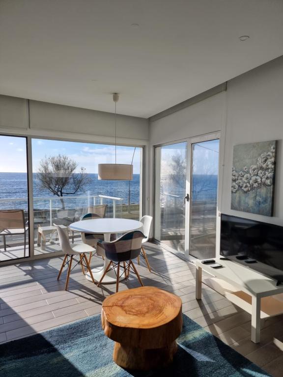 ein Wohnzimmer mit einem Tisch und Meerblick in der Unterkunft Bay House - Sealife Apartment in Ponta Delgada