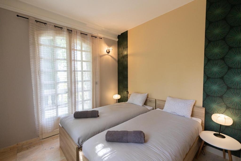 um quarto com 2 camas e uma janela em "Les Hauts du Marquet" - Meublé de tourisme 5 Etoiles - Gîte de groupe 15 Personnes en Cévennes - Piscine à débordement - Balnéo - Sauna - Nature em Saint Jean du Pin