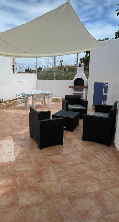 une terrasse avec des chaises, une table et une tente dans l'établissement Villa Ale, à Lampedusa