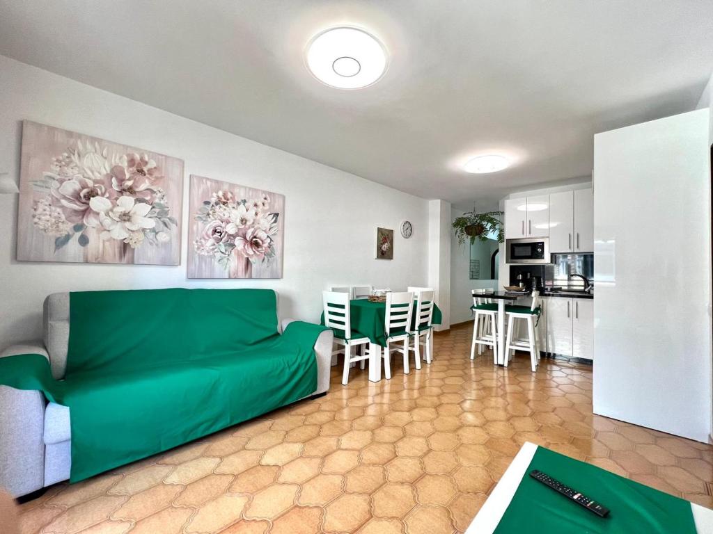 a living room with a green couch and a kitchen at Three bedroom apartment in center of Santa Cruz with Wifi and parking place in Santa Cruz de Tenerife