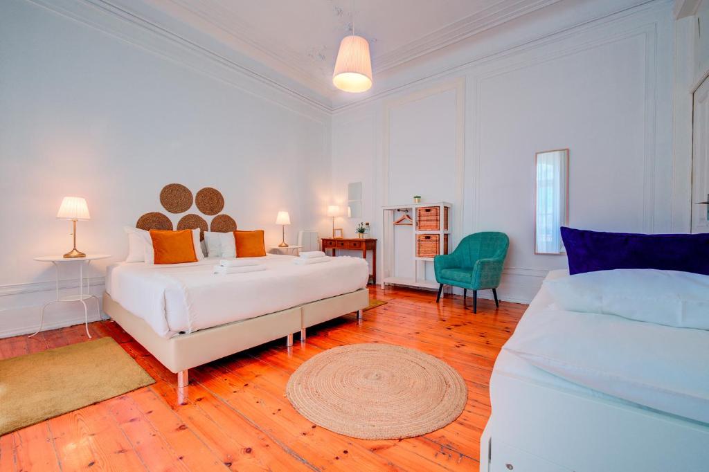 a large white bedroom with a bed and a couch at Chalet D´Ávila Guest House in Lisbon